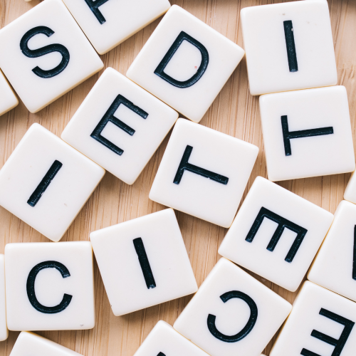 Scrabble tiles scattered on timber surface